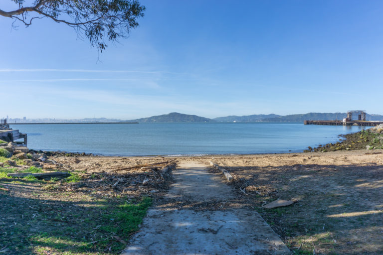 A paved path that ends at a sandy beach