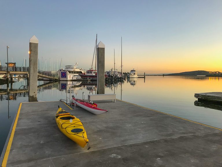 Two kayaks on a low-freeboard dock during sunset